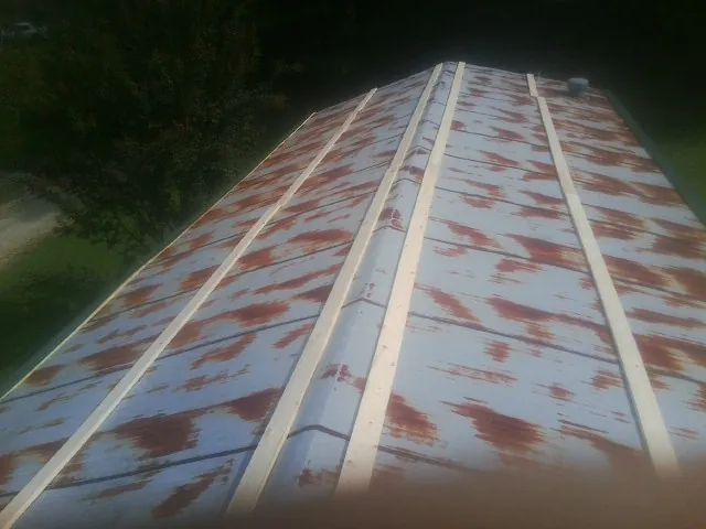 Rusted metal roof panels with new wood purlins before replacement — Storm Damage Roof Repair in Matlock by Roofing Brothers