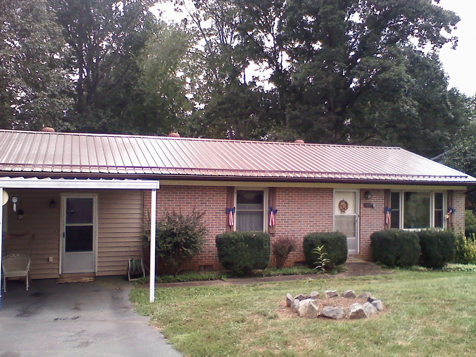 Bronze metal roof and carport on a brick ranch home — Roof Repair work by our crew in Matlock